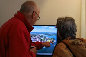 Två personer tittar på en digital skärm.