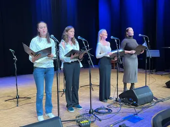 Fyra sångerskor i Vaxholms vokalensemble sjunger i Kronängsskolans aula.